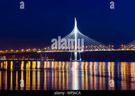 Cable-stayed bridge connects the roads of Western high-speed diameter in St. Petersburg, Russia. Night lighting of bridge is reflected in water of Pet Stock Photo