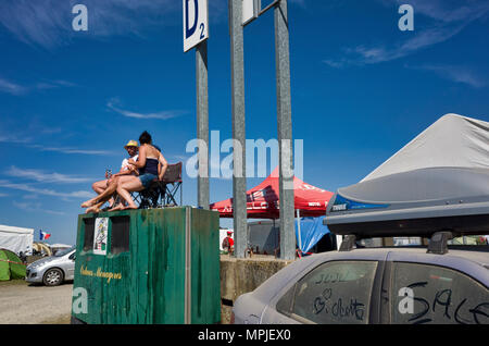 19-20th May 2018. Le Mans, France.  Behind the scenes at the MotoGP.  Campers set up their camp chairs upon a large waste container giving them a great view of the festivities stating up after the end of the MotoGP practice sessions. Stock Photo