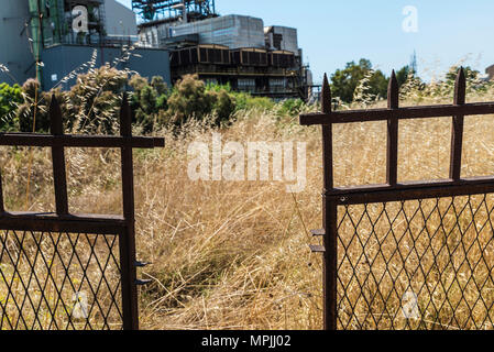 Rusted and pointed metal fence surrounding an abandoned oil refinery in Gela, Sicily, Italy Stock Photo