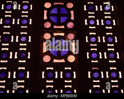 Abstract background of bright stained glass windows with violet and orange glass on a dark wall. Stock Photo