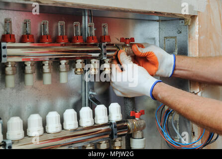 Installation of home heating. A worker attaches the tube to the collector heating. Stock Photo