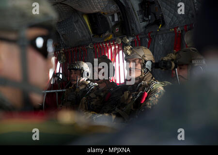 U.S. Marine Corps Staff Sgt. Xavier Ovando (left), Capt. Ben Skarzynski (center), and Sgt. Alexander Czub (right) wait to jump from U.S. Army CH-47 Chinook at Josari drop zone, Republic of Korea, March 17, 2017 as part of Korea Marine Exercise Program 17-6. KMEP is carried out in the spirit of the Republic of Korea-U.S. Mutual Defense Treaty signed between the two nations October 1, 1953. The Marines are with 3d Reconnaissance Battalion, 3rd Marine Division, III Marine Expeditionary Force. Ovando, a Los Angeles, California native, is the platoon sergeant. Skarzynski, is the platoon commander f Stock Photo