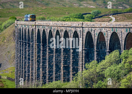 Ribblehead. United Kingdom.  Diesel train seen approaching Ribblehead station in the Yorkshire Dales after crossing the Ribblehead Viaduct. Stock Photo