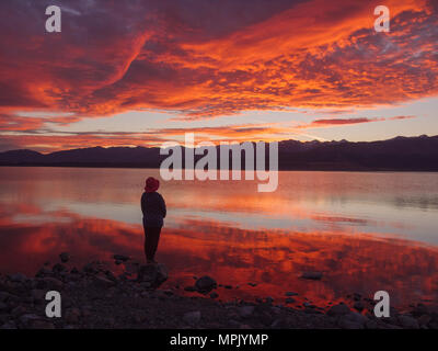 dreamer, silhouette of woman standing on the lake wooden pier at sunset, human strength, psychology concept Stock Photo