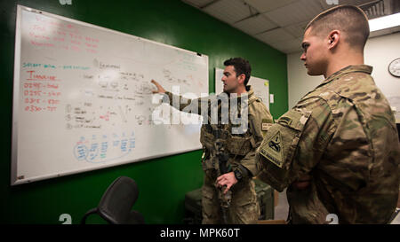 Air Force 2nd Lt. Dan, 83rd Expeditionary Rescue Squadron Guardian Angel team commander and combat rescue officer, and Army 1st Lt. Brett Rankowitz, 136th Infantry Battalion Chosen Company 2nd Platoon Aerial Reaction Force leader, discuss personnel recovery tactics prior to a training exercise March 7, 2017 at Bagram Airfield, Afghanistan. Guardian Angel teams here are comprised of pararescuemen; combat rescue officers; and survival, evasion, resistance and escape specialists who are trained in combat search and rescue and are responsible for Air Force personnel recovery throughout Afghanistan Stock Photo