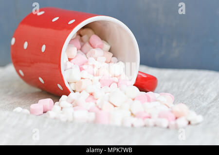 Red polka dot Cup filled marshmallow on gray fabric Stock Photo