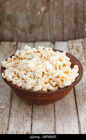 Fresh popcorn in bowl on white wooden table. Selective focus. Stock Photo