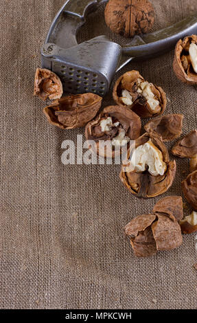 walnuts and a nutcracker on a table covered with burlap Stock Photo