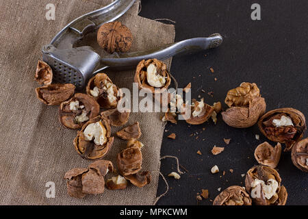 walnuts and a nutcracker on a table covered with burlap Stock Photo