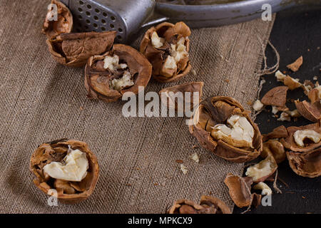 walnuts and a nutcracker on a table covered with burlap Stock Photo