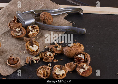 walnuts and a nutcracker on a table covered with burlap Stock Photo
