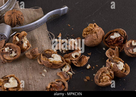 walnuts and a nutcracker on a table covered with burlap Stock Photo