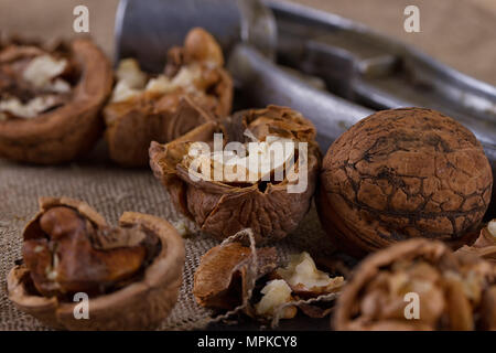 walnuts and a nutcracker on a table covered with burlap Stock Photo