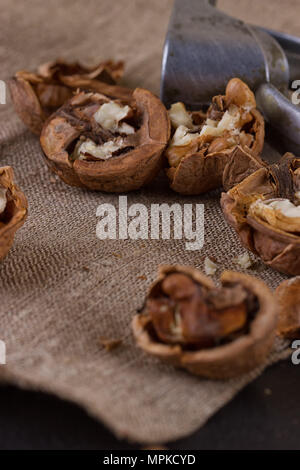walnuts and a nutcracker on a table covered with burlap Stock Photo