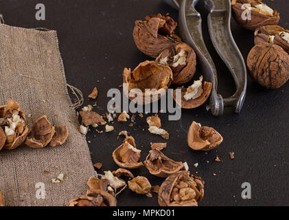 walnuts and a nutcracker on a table covered with burlap Stock Photo
