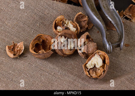 walnuts and a nutcracker on a table covered with burlap Stock Photo
