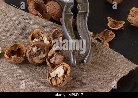 walnuts and a nutcracker on a table covered with burlap Stock Photo