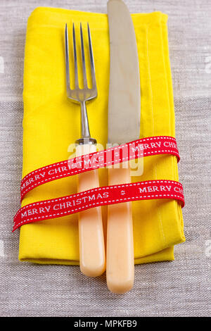 Fork, spoon and knife tied with a red ribbon Stock Photo