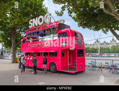 Shocking pink or fluoresecent red brightly coloured double decker bus converted for selling Snog frozen yogurt on South Bank Embankment, London SE1 Stock Photo