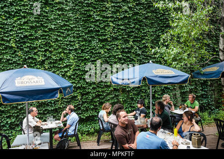 Montreal Canada,Quebec Province,rue Ontario,Chez Clo Restaurant Bistro,al fresco sidewalk outside outdoors tables,dining,umbrella,ivy,tables,visitors Stock Photo