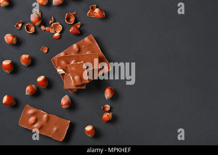 Chocolate with hazelnuts, mint and grains of coffee on a dark gray table Stock Photo