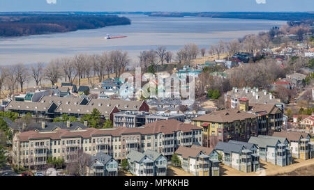 Tug boat pushing barges up the Mississippi River past the residential Harbor Town neighborhood on Mud Island in Memphis, Tennessee Stock Photo