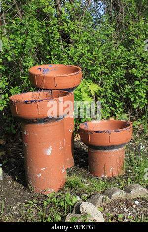Three unusual looking empty terra cotta plant holders ready for springtime planting. Stock Photo