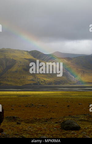 Rainbow over rocky plain with grey sky in Thorsmork National Park, Iceland Stock Photo