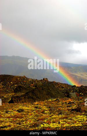 Rainbow over rocky landscape against a grey cloudy sky, Thorsmork, Iceland Stock Photo