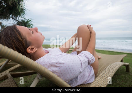 caucasian woman relaxing in chair near indian ocean in Srilanka. Stock Photo