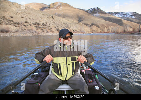 man fly fishing on river with rubber pontoon raft Stock Photo - Alamy