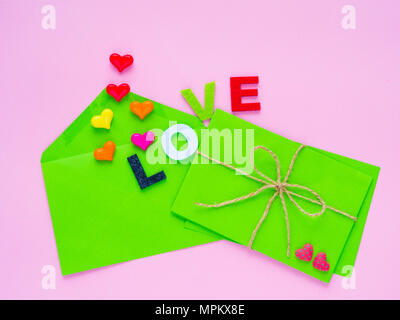 love letter concept. Opened envelope and many felt hearts. colorful of hearts with LOVE text on pink background. Stock Photo