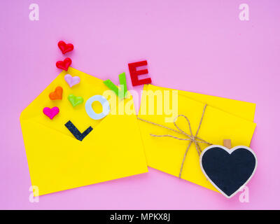 love letter concept. Opened envelope and many felt hearts. colorful of hearts with LOVE text on pink background. Stock Photo