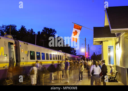 Canada,Canadian,Charny,VIA Rail train station,VIA Rail passenger car,platform,flag,dusk,evening,transportation,Canada070708125 Stock Photo