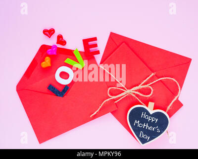 Happy Mother's day love letter concept. Opened envelope and many felt hearts. colorful of hearts with LOVE text on pink background. Stock Photo