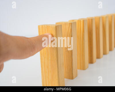 Concept of building success foundation. Chain Reaction In Business Concept, Businessman Letting Or Preventing Dominoes Continuous Toppling On Rustic W Stock Photo