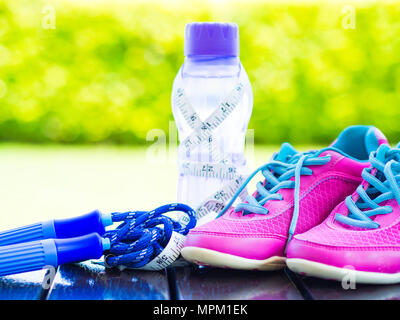 Running shoes, jump rope and drink bottle with green juice Stock