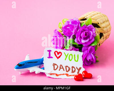 Father's day concept. I LOVE YOU DADY message with red rose, two red heart, airplane model and gift on pink background Stock Photo