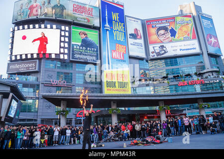 Toronto Canada,Yonge Street,Dundas Square,public plaza,Toronto's Time Square,street performer,busking tips,fire juggler,busker,AMC theater,theatre,mov Stock Photo