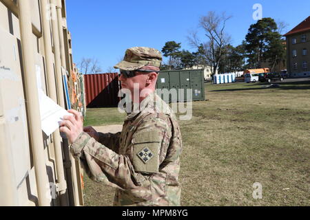 Staff Sgt. Tomasz Sobota, an infantryman and operations sergeant for Headquarters and Headquarters Company, 3rd Armored Brigade Combat Team, 4th Infantry Division, inspects the packing list on a container in Zagan, Poland, March 27, 2017. Sobota, a native of Poland, has played a critical role as interpreter and ambassador for 3/4 ABCT in Poland, where the brigade kicked off its nine-month rotation in support of Operation Atlantic Resolve. (U.S. Army photo by Staff Sgt. Ange Desinor, 3rd Armored Brigade Combat Team Public Affairs, 4th Infantry Division) Stock Photo