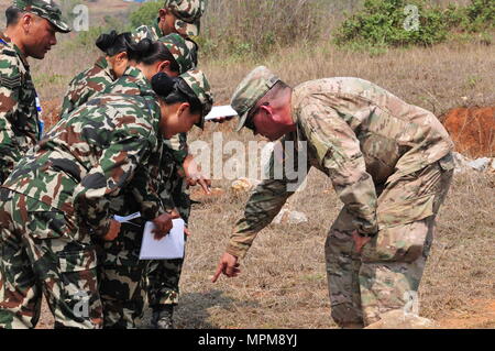 Sgt. 1st Class Christopher Warhawk helps soldiers from the Nepalese Army identify an improvised explosive device during Multinational Peacekeeping Exercise Shanti Prayas III March 24 at the Birendra Peace Operations Center in Panchkhal, Nepal. Shanti Prayas is a multinational United Nations peacekeeping exercise designed to provide pre-deployment training to U.N. partner countries in preparation for real-world peacekeeping operations. (U.S. Army photo by Staff Sgt. Michael Behlin) Stock Photo