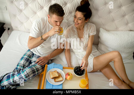 Young loving couple having breakfast in bed Stock Photo