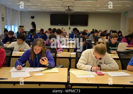 Students participate in the written portion of the Carderock Math Contest in West Bethesda, Maryland, on March 24, 2017, solving timed mathematics problems. The contest emphasizes STEM education, problem-solving skills, and critical thinking. Participants demonstrate computational proficiency, speed, and accuracy while engaging in an academic competition designed to challenge and develop mathematical reasoning. Stock Photo
