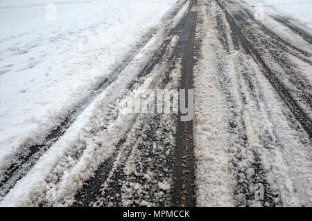 Snow on road in winter with traces of car tires. Stock Photo