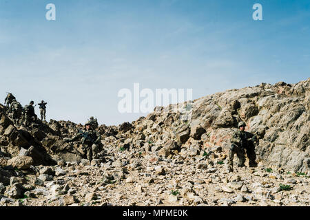Infantry soldiers ruck up a rocky outcrop near Kandahar, Afghanistan, March 14, 2017. The soldiers were part of a security detachment supporting Afghan Tactical Air Coordinators and advisors from Train, Advise, Assist Command-Air. As part of Resolute Support Mission, TAAC-Air works in tandem with their Afghan counterparts to foster working relationships and fortify confidence in the mission. (U.S. Air Force photo by Senior Airman Jordan Castelan) Stock Photo