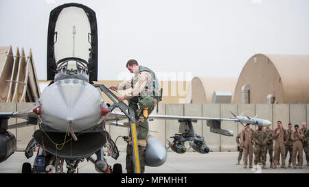 Lt. Col. Craig Andrle, 79th Expeditionary Fighter Squadron commander, climbs down from an F-16 Fighting Falcon as members of the 79th EFS wait to congratulate him on flying his 1,000th combat hour March 20, 2017 at Bagram Airfield, Afghanistan. Andrle reached the milestone while supporting the wing’s counterterrorism mission in Afghanistan. (U.S. Air Force photo by Staff Sgt. Katherine Spessa) Stock Photo