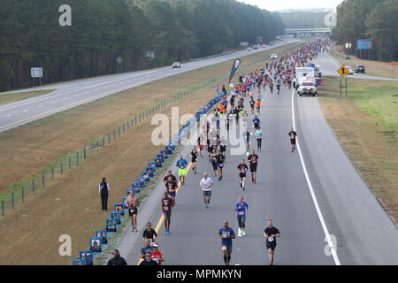 Runners of the All American Marathon move past a section of the competition that is dedicated to fallen service members Mar. 26, 2017, in Fayetteville, N.C. The memorial was put up by volunteers with the organization, wear blue: run to remember, who supported the event by lining a portion of the race with photos of fallen service members and holding flags in honor of the nation’s fallen heroes past and present. (U.S. Army photo by Pfc. Hubert D. Delany III/22nd Mobile Public Affairs Detachment) Stock Photo