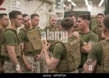 USS SOMERSET, At Sea (March 27, 2017) U.S. Marine Sgt. Scott Ingram, center, a light armored vehicle Marine with Light Armored Reconnaissance Company, Battalion Landing Team 1st Bn., 4th Marines, 11th Marine Expeditionary Unit (MEU), demonstrates the counter to a round punch technique during a Marine Corps Martial Arts Program training session aboard USS Somerset (LPD 25), March 27. During the training, the Marines practiced pain manipulation, counter strike, and knife techniques. The 11th MEU is operating in the U.S. 5th Fleet area of responsibility in support of maritime security operations  Stock Photo