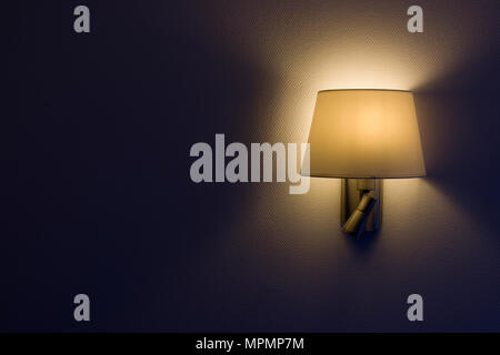 Wall lamp, night light in a dark background,yellow shade.