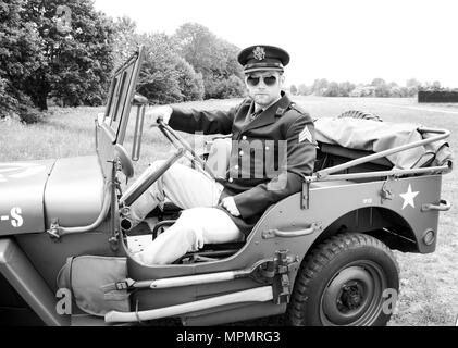 Handsome American WWII GI Army officer in uniform riding Willy Jeep Stock Photo